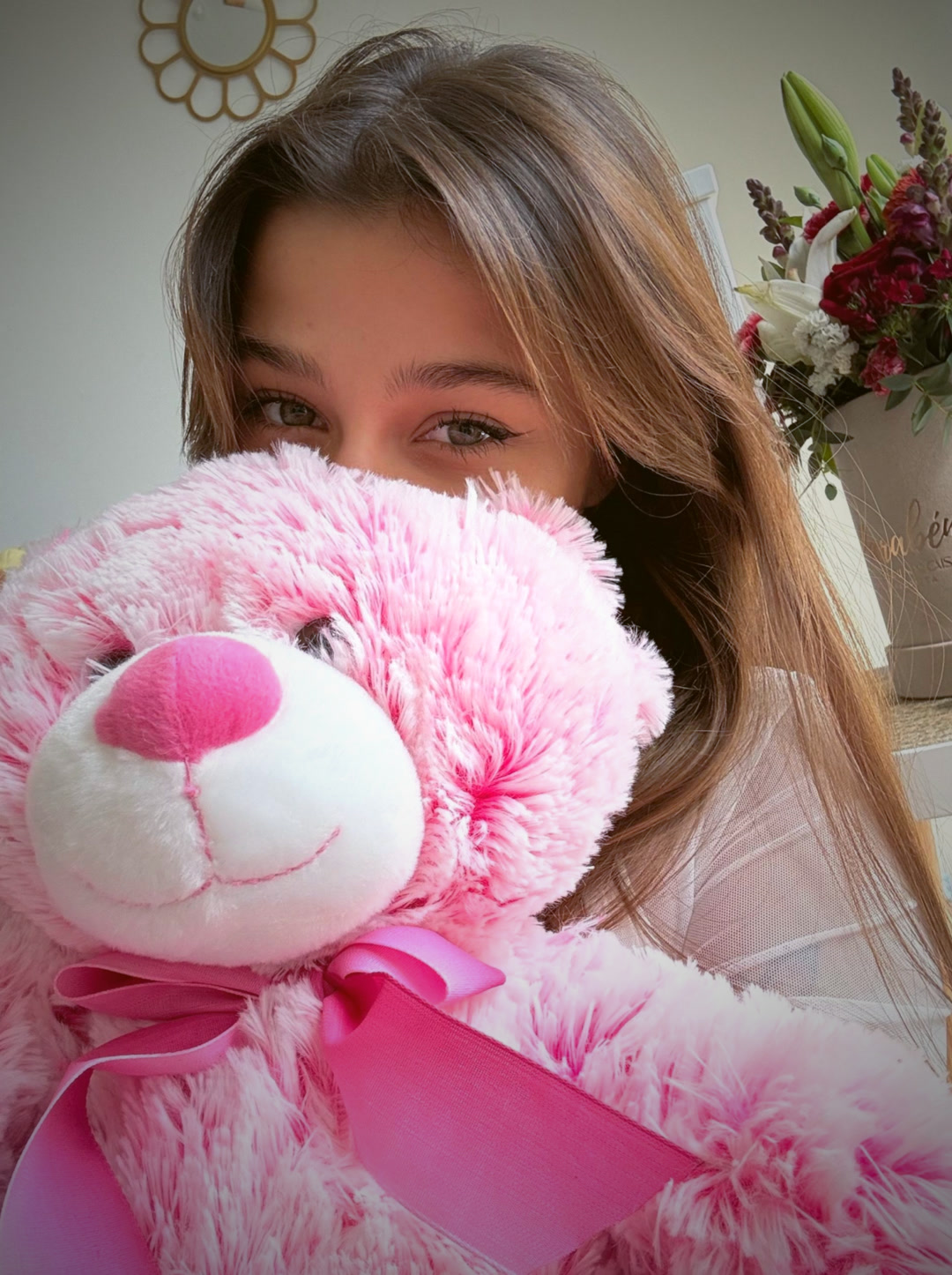 Hiding behind a pink teddy bear